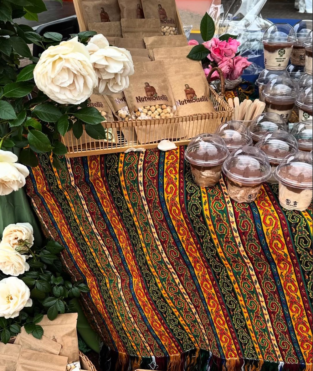Marktstand mit Kelim, weißen Rosen, Beuteln und Desserts